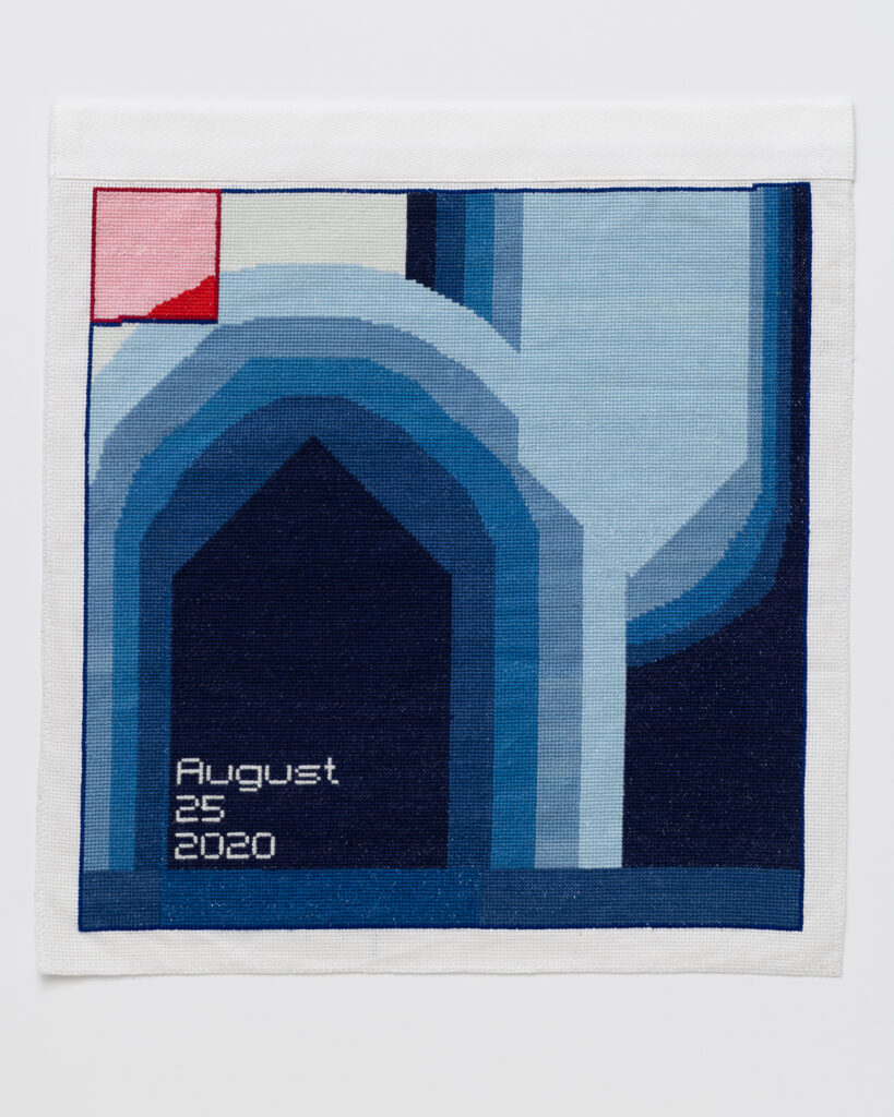 Cross stitch embroidery of abstsract blue shapes in varying colors. Dark arch shape on the left side outlined with lighter shades of blue. 