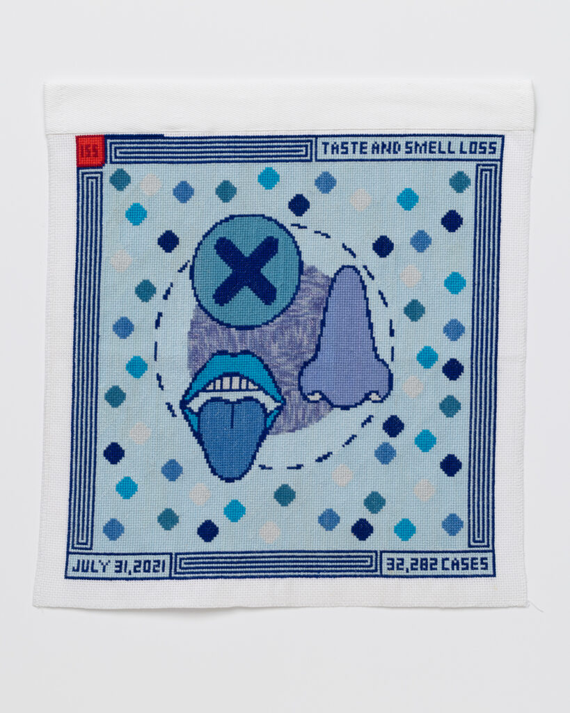 Cross stitch embroidery with a few circles in the middle. One circle has a dark blue 