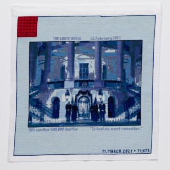 Photo by Wes Magyar Cross stitch embroidery of picture of President Biden in front of the White House, standing with other figures, stitched in blue threads. There is a solid light blue border around the image, with "THE WHITE HOUSE 22.February.2021" written above, and "500 candles- 500,000 deaths To heal we must remember." written below. There is a red square in the upper left corner.